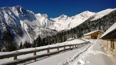 a snow covered mountain with a building and a road at 