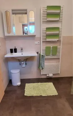 a bathroom with a sink and a mirror and a rug at B&B Gasthaus Lieg in Castelrotto