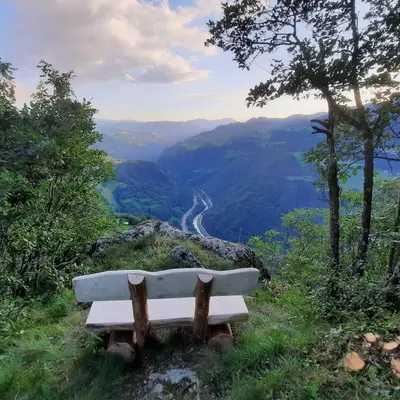 a white bench sitting on top of a hill at B&B Gasthaus Lieg in Castelrotto