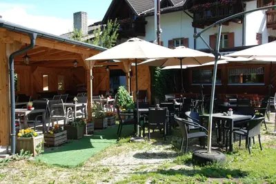 a restaurant with tables and chairs and umbrellas at Gasthof zum Schlern in Fiè