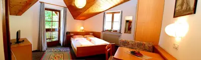 a bedroom with a bed and a table in a room at Gasthof zum Schlern in Fiè