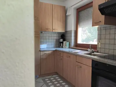 a kitchen with wooden cabinets and a sink and a window at Maurerhof Apartments Kronplatz in San Lorenzo di Sebato