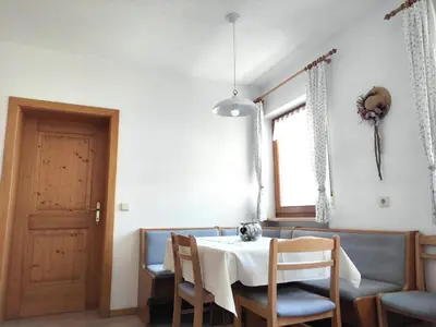 a dining room with a table and chairs and a door at Maurerhof Apartments Kronplatz in San Lorenzo di Sebato
