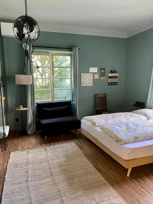 a bedroom with a bed and a chair and a window at sleep & go -Meran easy staying in Merano