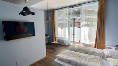 a living room with a couch and a large window at sleep & go -Meran easy staying in Merano