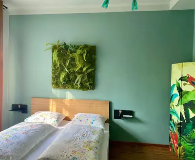 a bedroom with a bed and a painting on the wall at sleep & go -Meran easy staying in Merano