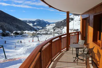 a balcony with a table and a view of a ski slope at Hotel Garni Aghel in Selva di Val Gardena