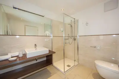a bathroom with a shower and a sink and a toilet at Hotel Garni Aghel in Selva di Val Gardena