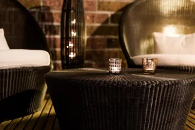 a table with two votive candles on top of it at Hotel Garni Aghel in Selva di Val Gardena