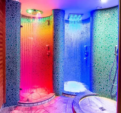 a bathroom with a colorful shower with a tub at Hotel Garni Aghel in Selva di Val Gardena