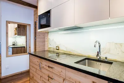 a kitchen with wooden cabinets and a sink at Apartments Aghel ***S in Selva di Val Gardena