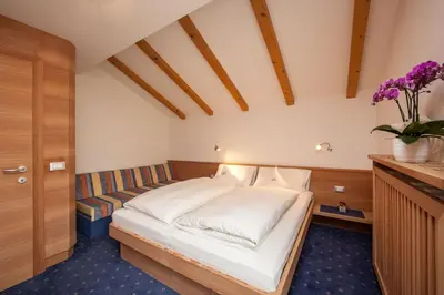a bedroom with a bed and a couch at Apartments Aghel ***S in Selva di Val Gardena