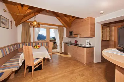 a kitchen and dining room with a table and chairs at Apartments Aghel ***S in Selva di Val Gardena
