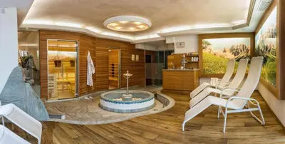 a bathroom with a tub and a table and chairs at Apartments Aghel ***S in Selva di Val Gardena