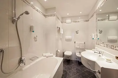 a bathroom with a tub and a sink and a toilet at Apartments Aghel ***S in Selva di Val Gardena