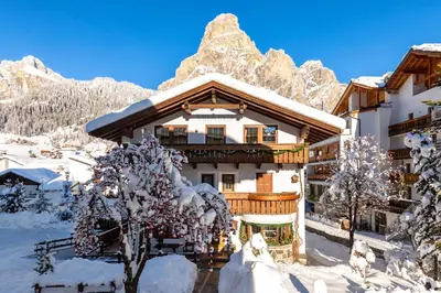 a ski lodge in the mountains covered in snow at Villa Resi Apartments in Corvara in Badia