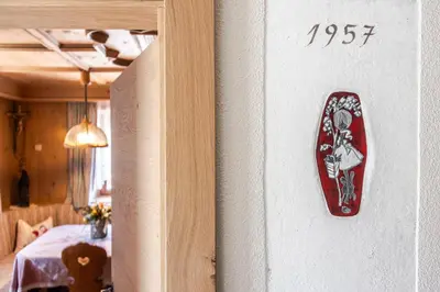 a sign on a wall next to a bedroom at Villa Resi Apartments in Corvara in Badia