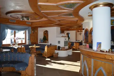 a living room with a coffered ceiling and wooden furniture at Hotel Villa Aurora in San Martino di Castrozza
