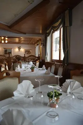 a dining room with tables with white tablecloths at Hotel Villa Aurora in San Martino di Castrozza