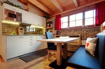 a kitchen with a table and chairs in a room at Appartamenti Pastüres in Colfosco