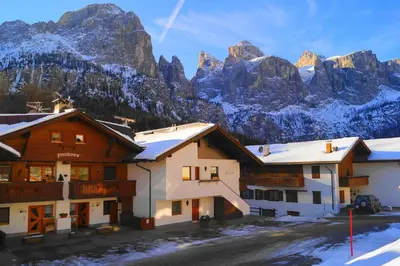 a group of buildings with mountains in the background at Appartamenti Pastüres in Colfosco