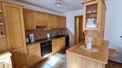 a kitchen with wooden cabinets and a counter top at Appartamento Cesa Lamar in Canazei