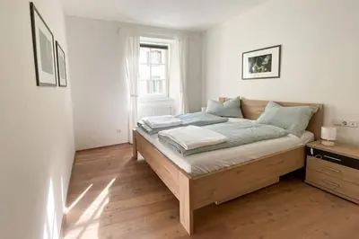 a bedroom with a bed in a white room at In Urbi, city appartement in Bressanone