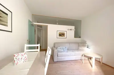 a living room with a white couch and a table at In Urbi, city appartement in Bressanone