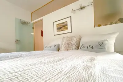 a bedroom with a large white bed with love pillows at In Urbi, city appartement in Bressanone