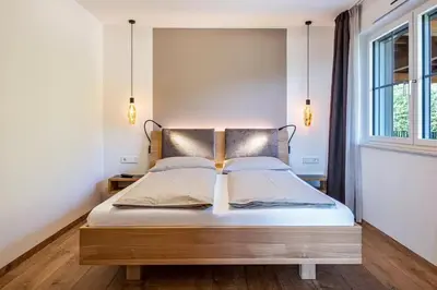 a bedroom with a bed with a headboard and a window at Nofnerhof in Appiano sulla Strada del Vino