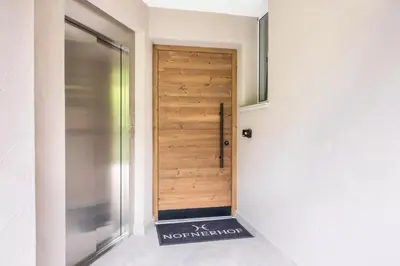 a wooden door in a hallway with a sign in front of it at Nofnerhof in Appiano sulla Strada del Vino
