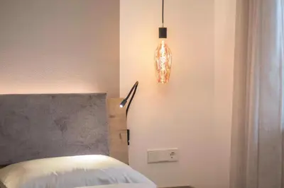 a bedroom with a bed and a light fixture at Nofnerhof in Appiano sulla Strada del Vino
