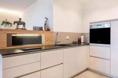 a kitchen with white cabinets and a black microwave at Nofnerhof in Appiano sulla Strada del Vino