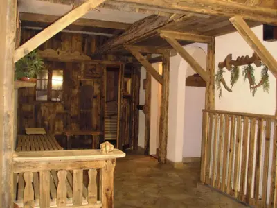 a room with a bench in a room with wooden ceilings at Hotel Rosalpina in Rocca Pietore