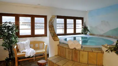 a large bathroom with a hot tub in a room at Hotel Rosalpina in Rocca Pietore