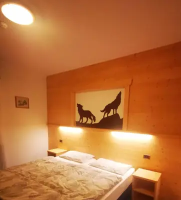 a bedroom with a bed with a picture of wolves at Hotel Rosalpina in Rocca Pietore
