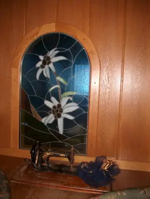 a stained glass window with white flowers on it at Hotel Rosalpina in Rocca Pietore