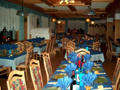 a dining room with blue tables and chairs at Hotel Rosalpina in Rocca Pietore