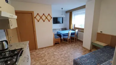a kitchen with a table and a dining room at Apartments Gana in La Villa
