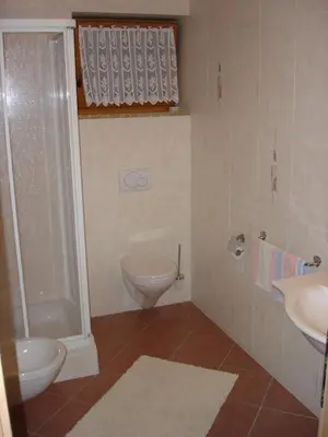 a bathroom with a toilet and a sink at Apartments Gana in La Villa