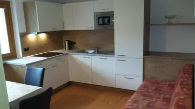 a kitchen with white cabinets and a sink at Apartments Gana in La Villa