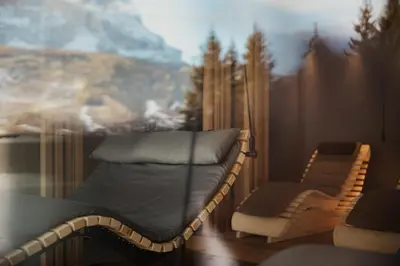 a bed and a chair in a room with a painting at Residence Ciasa Vedla in Badia