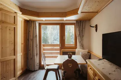 a small living room with a table and a window at Residence Ciasa Vedla in Badia