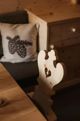 a light on a table next to a bed at Residence Ciasa Vedla in Badia