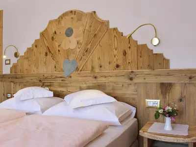 a bedroom with two beds with a wooden headboard at Hotel Cesa Padon in Arabba