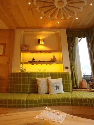 a green bench in a room with a window at Hotel Cesa Padon in Arabba
