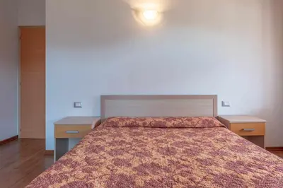 a bedroom with a large bed with two night stands at Appartamento alla Brisa Grauno Ospitar in Grauno