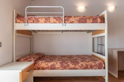 two bunk beds in a room with a desk at Appartamento alla Brisa Grauno Ospitar in Grauno