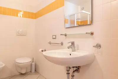 a bathroom with a sink and a toilet at Appartamento alla Brisa Grauno Ospitar in Grauno