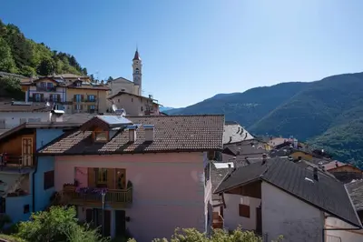 a group of buildings in a town with mountains at Appartamento alla Brisa Grauno Ospitar in Grauno